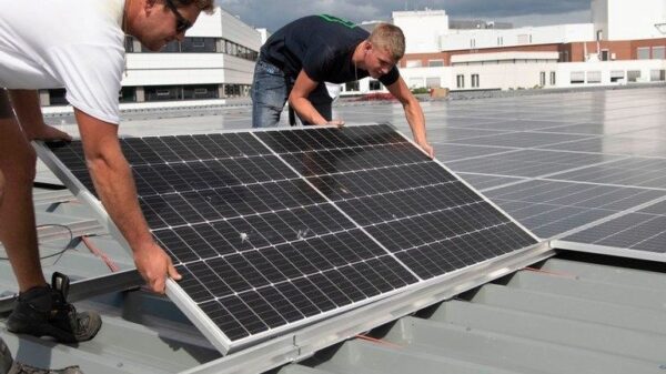 Twee mannen leggen zonnepanelen op een dak